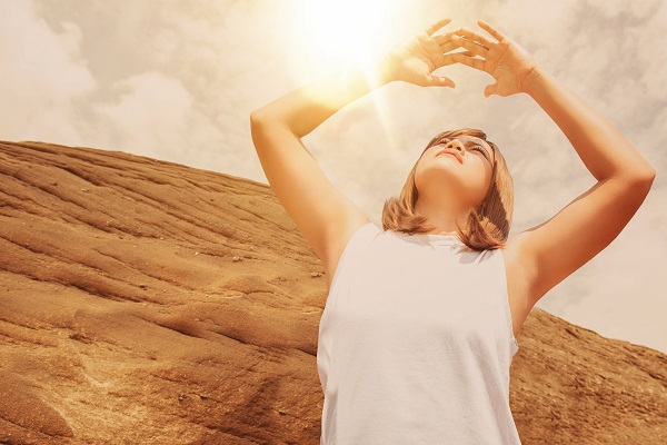 Woman blocking eyes while looking at the sun