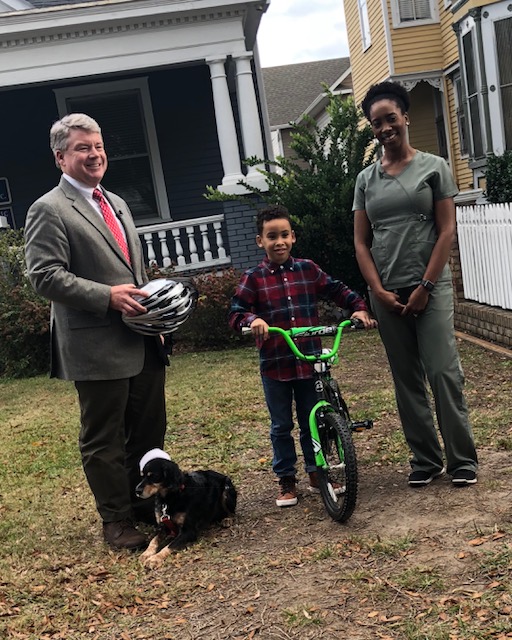 Gary Bruce Giving Helmet to Child In Need at Safe Kids Columbus' Annual Helmet Giveaway