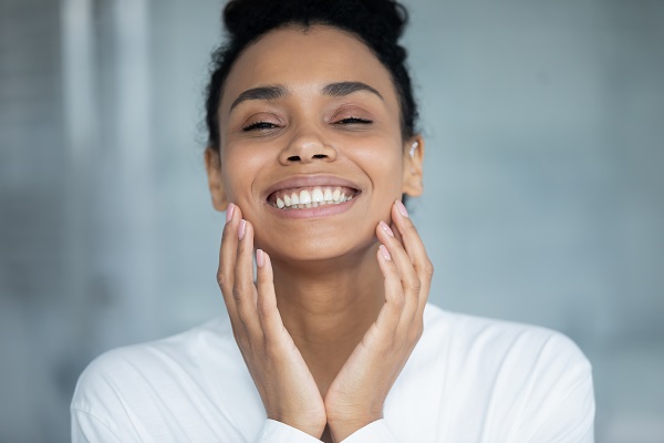 Woman smiling and touching face