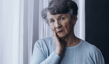 Woman with headache while trying to make dinner for her family