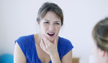 Woman with headache while trying to make dinner for her family