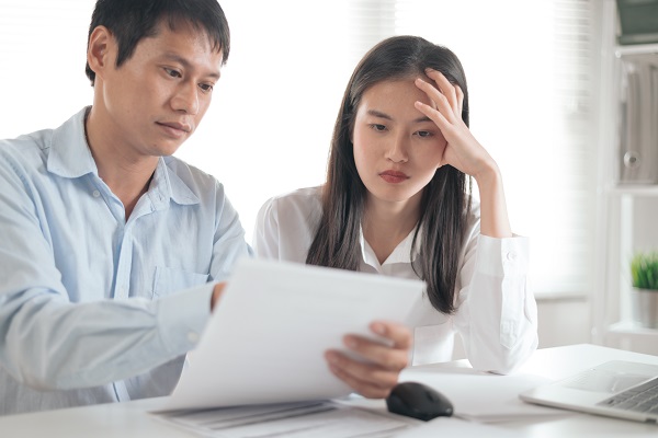 Couple looking at bills and wondering how they will make ends meet