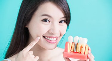 Young Woman Demonstrating How Dental Implants Replaced Her Missing Tooth