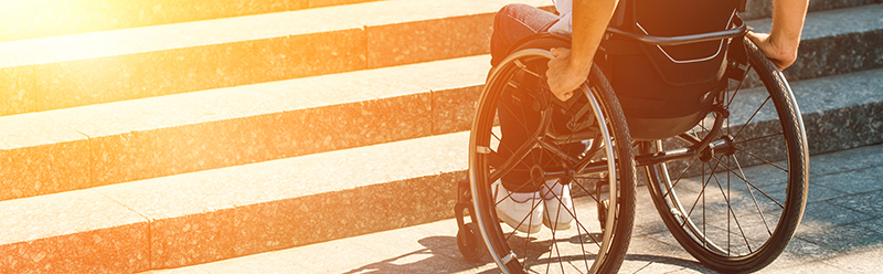 Man with a disability in a wheelchair goes over crosswalk in British Columbia