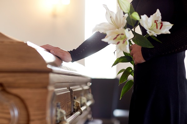 Hand touching a casket