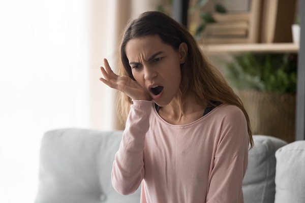 Woman with jaw pain placing hand on one side of open mouth